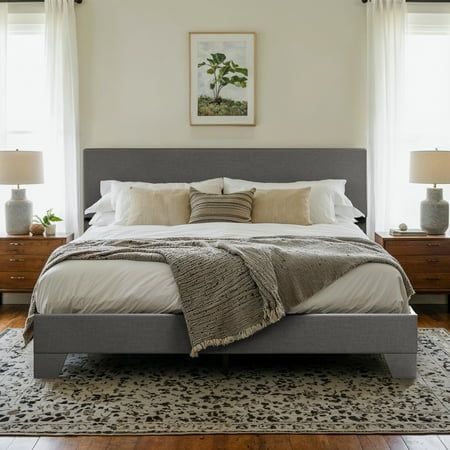 a large bed sitting in a bedroom next to two windows