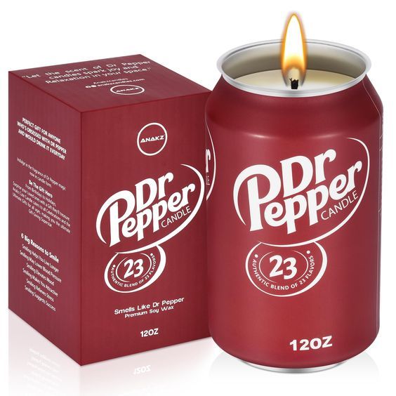 a candle that is next to a red box with the word dr pepper on it