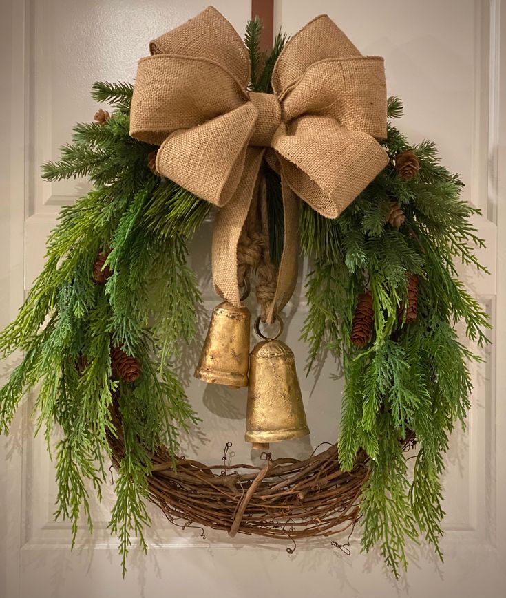 a wreath with evergreen, pine cones and bells