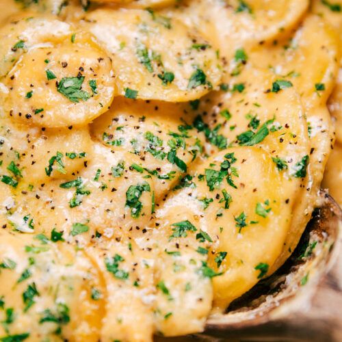 a close up view of some food in a bowl with parsley on top and seasoning