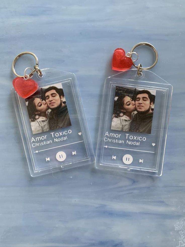 two clear plastic keychains with an image of a man and woman on them