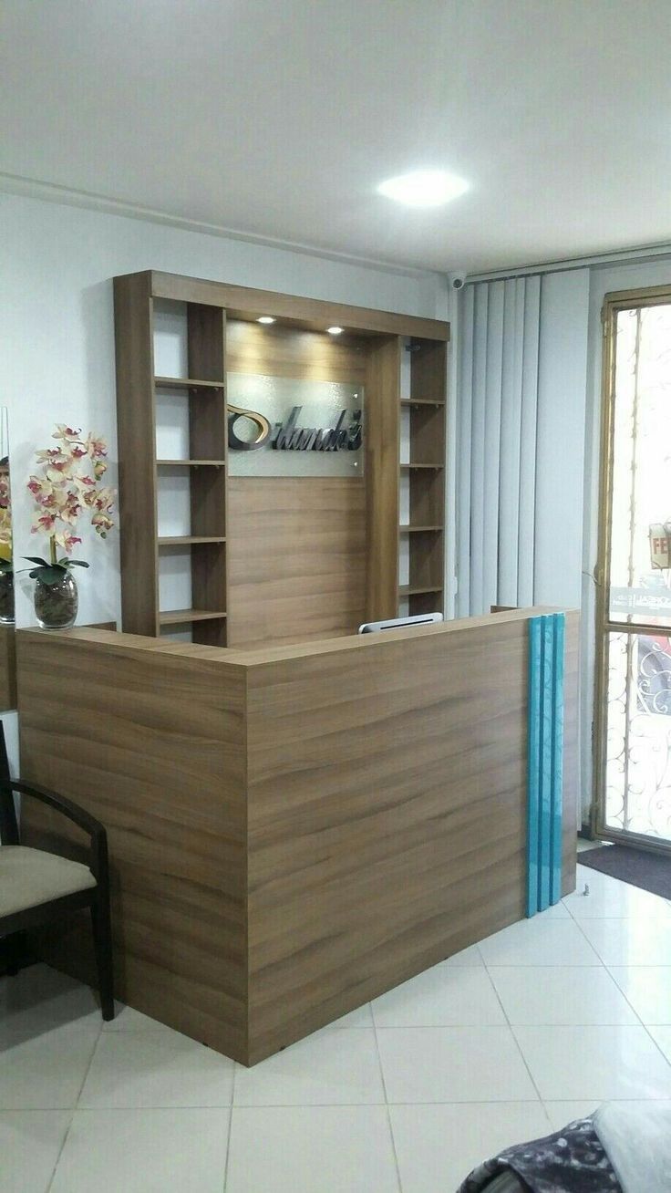 the front desk of an office with a chair and bookcases in the background