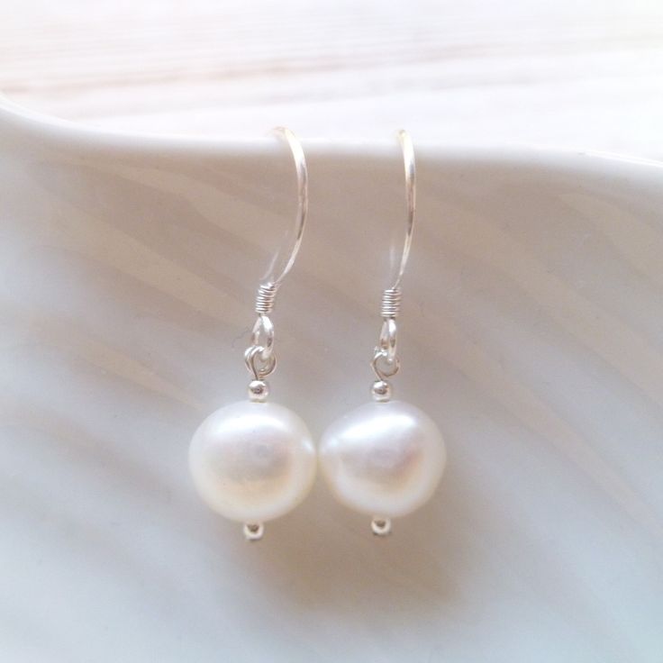 Pearl drop dangle earrings serve as a dainty and elegant accent without overpowering the rest of your outfit making them ideal as part of a bridal outfit or for the bridesmaids at your wedding.  The moment you choose to wear dainty pearl drop earrings, either basic or statement-like, it's best to tie up your hair in a bun or a more sophisticated updo to let the earrings stand out and enhance your facial features.  FEATURES: * real cultured freshwater pearls * ivory white with beautiful lustre * White Dangle Bridal Earrings, White Drop Earrings For Bridesmaid Gift, Delicate White Pearl Earrings For Bridesmaids, White Sterling Silver Earrings For Wedding, White Sterling Silver Bridal Earrings For Pierced Ears, Elegant White Pearl Earrings Nickel Free, Elegant White Earrings For Bridesmaid Gift, Classic White Teardrop Sterling Silver Earrings, Elegant White Nickel-free Pearl Earrings