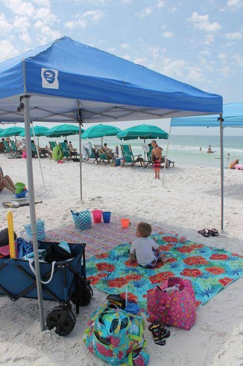 people are sitting under umbrellas on the beach