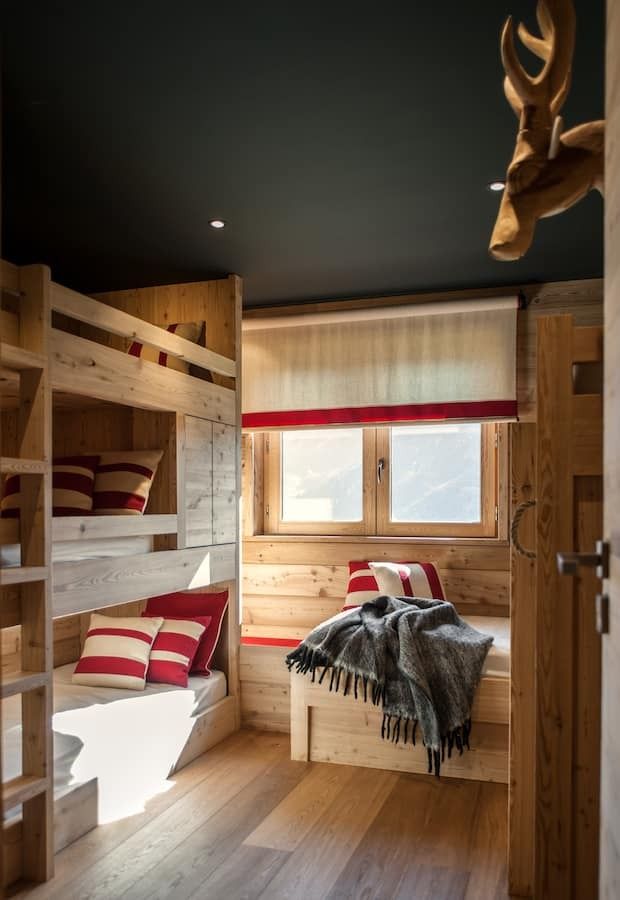 a bedroom with bunk beds and wooden walls