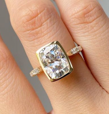 a woman's hand with a ring on it and a cushion shaped diamond in the middle