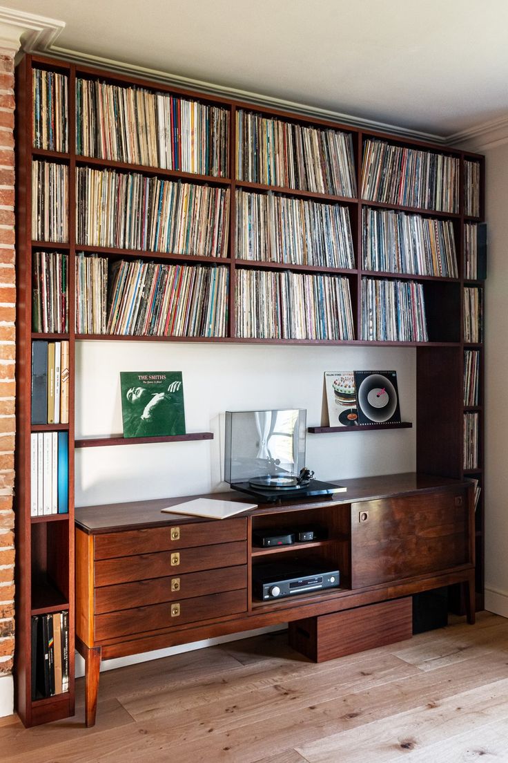 a record player is sitting on top of a shelf with many books and cds in it