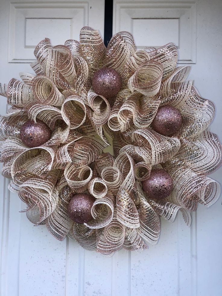 a wreath made out of newspaper strips with ornaments hanging on the front door and side