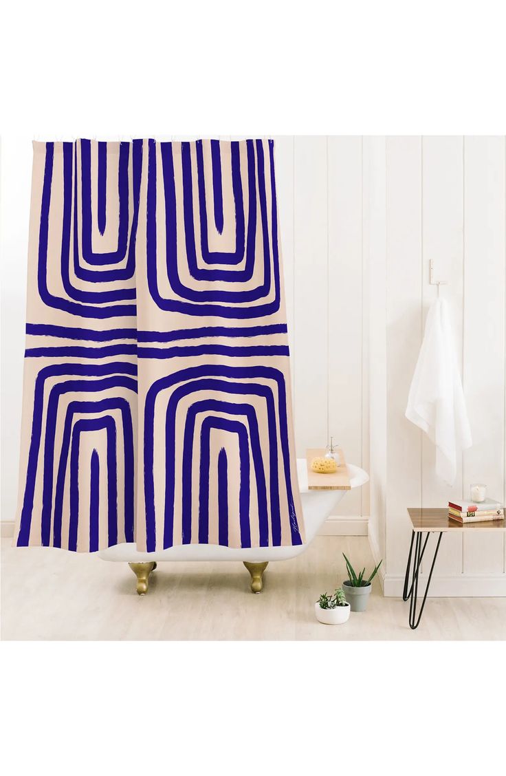 a blue and white shower curtain hanging on a wall next to a bathtub in a bathroom