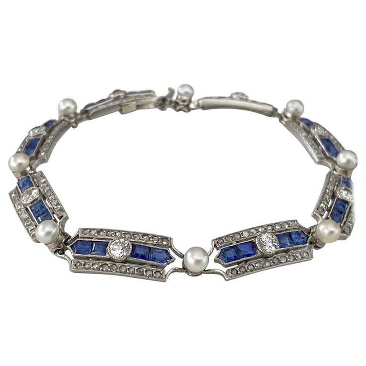 Circa 1910-1915, this magnificent antique French Belle Epoque link bracelet is composed of a repeating geometrical design centered by an Old European cut diamond flanked by four calibrated blue sapphires and two rows of small glittering rose cut diamonds. The links are connected by a single white pearl (8 in total) measuring 4mm. The bracelet measures 7.3 inches long and is fashioned in platinum with delicate milgrain hand-engraving. The diamonds total approximately 2.00 carats. Sapphire And Pearl, Geometrical Design, European Cut Diamonds, Dream Jewelry, Belle Epoque, Rose Cut Diamond, Hand Engraving, Pearl Bracelet, Rose Cut