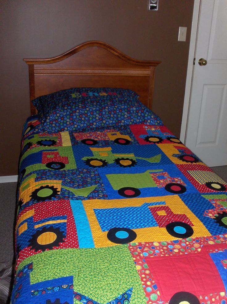 a bed with a colorful quilt on it and a door to the bedroom in the background