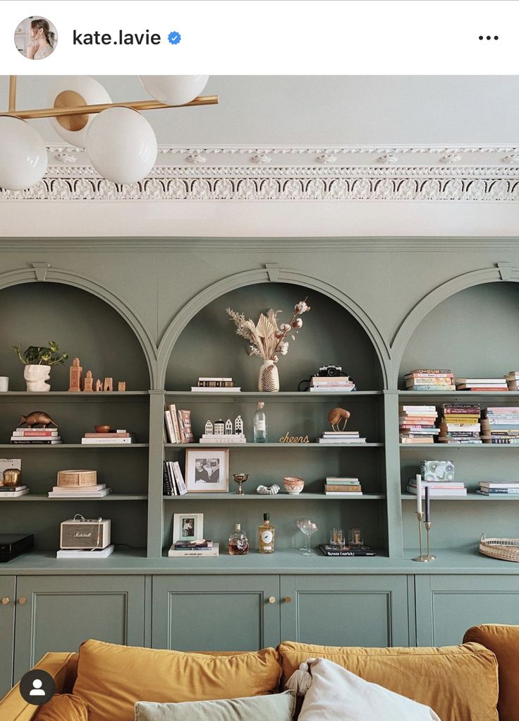 a living room filled with lots of furniture and bookshelves on top of shelves