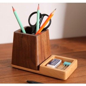 a wooden pen holder with several pencils in it