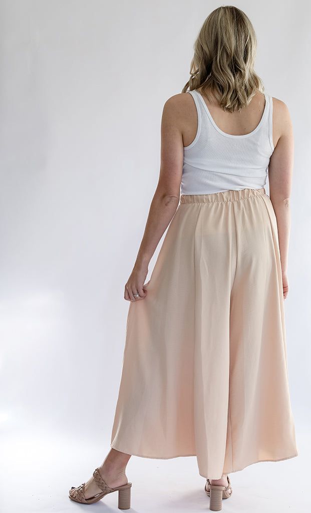 Be the talk of every room with our Keep it Glowing - Woven Wide Leg Pants! These champagne, satin pants are beyond gorgeous. They give the illusion of a skirt, but bring the comfort of pants. This item has a high waist, elastic waist band, and pockets. We love these so much because you can throw on a blouse to dress them up, or a tank to dress them down. You can wear these for any occasion and be the most stylish gal in the room! - Champagne colored woven wide leg pants - High waist - Elastic wa Wide-leg Pants With Elastic Waistband For Daywear, Full Length Rayon Bottoms For Work, Feminine Wide Leg Bottoms For Daywear, Feminine Wide Leg Pants For Loungewear, Full Length Rayon Pants With Elastic Waistband, Spring Harem Pants With Elastic Waistband, Chic Full-length Culottes With Elastic Waistband, High-waisted Wide Leg Pants With Elastic Waistband, Chic Stretch Bottoms With Banded Waist