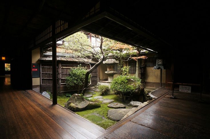 an indoor garden with rocks and trees in the center, surrounded by wood flooring