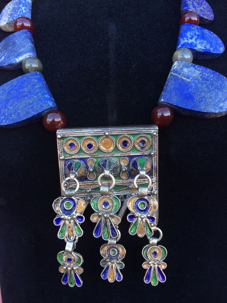 "REDUCED from $650 Striking necklace composed of large one-side-rounded, one-side-straight, slabs of gorgeous raw matte Lapis Lazuli in graduated sizes (largest to the front), separated by green Labradorite & Carnelian ball-shaped-beads, framing a fabulous Moroccan Berber enamel & tribal-silver-metal prayer-amulet/talisman pendant box with 6 freely dangling parts, also in matching tribal-silver-metal & enamel, that may be abstracted Hamsa symbols or flowers(?). Smaller Labradorite be Unique Spiritual Jewelry For Festivals, Spiritual One-of-a-kind Jewelry For Festivals, Traditional Sterling Silver Necklaces With Natural Stones, Amulet Style Gemstone Necklace For Festival, Artisan Jewelry With Large Pendant For Festivals, Artisan Large Pendant Jewelry For Festivals, Artisan Necklaces With Large Pendant For Ceremonial Use, Handmade Healing Jewelry For Festivals, Amulet Style Necklaces With Natural Stones For Festivals