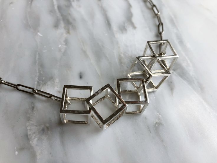 "Make a statement with this unusual necklace. Forming part of my cube collection, this necklace makes quite the impact. I always get compliments when I wear this necklace and I love it! It would make a great unique wedding day necklace too. Each cube is interlocked by sawing a side, hooking the next cube in and then soldering the cube back together. It's quite a process! Forming part of the cube collection by Silver Sculptor, this necklace comes in various chain lengths. The Cube Collection has 3d Necklace, Unusual Necklace, Modern Necklace, Silver Necklace Statement, Bib Necklaces, Necklace Unique, Geometric Necklace, Modern Necklaces, Necklace Statement