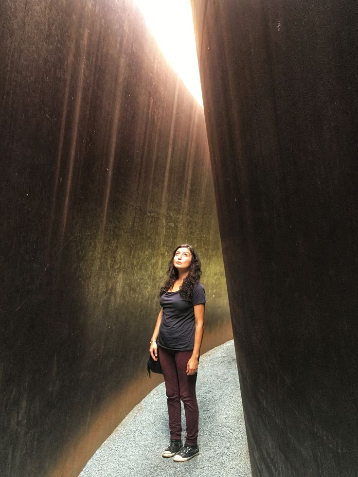 a woman standing in the middle of a tunnel with her eyes closed and looking up