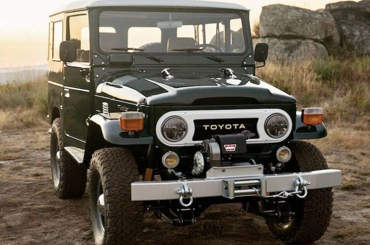 a black and white toyota truck parked in the dirt