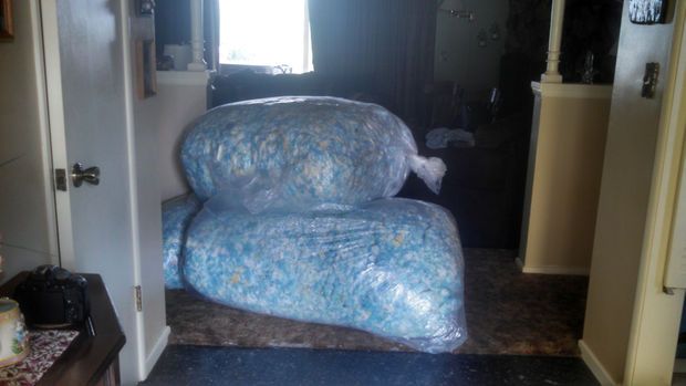 a blue couch sitting in the middle of a living room next to a doorway with an open door