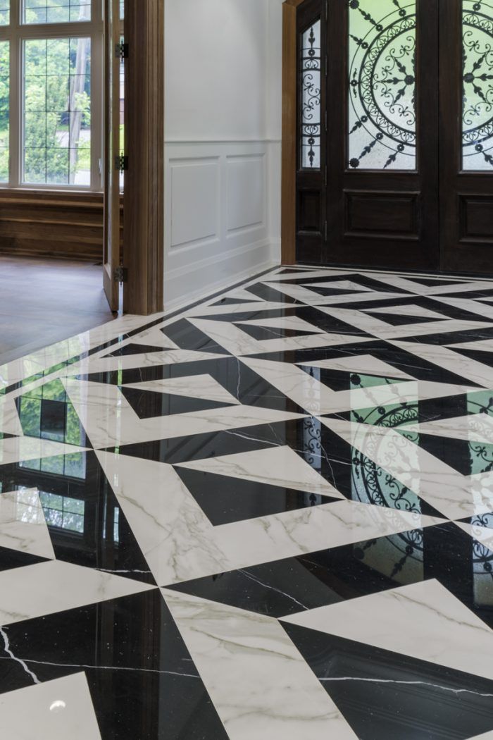 a black and white checkered floor in an empty room with two doors on either side