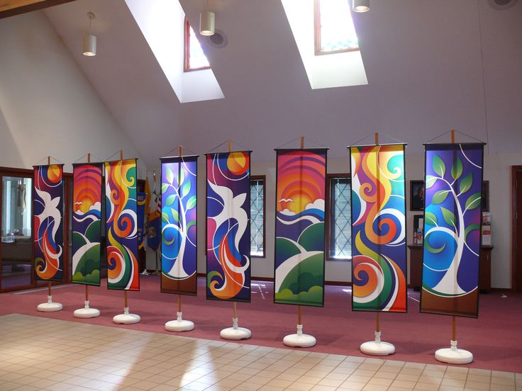 an empty room with colorful paintings on the walls and floor, along with white pedestals