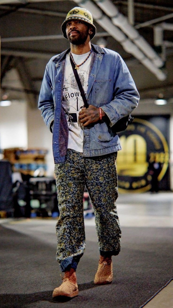 a man standing in an airport with his hat on