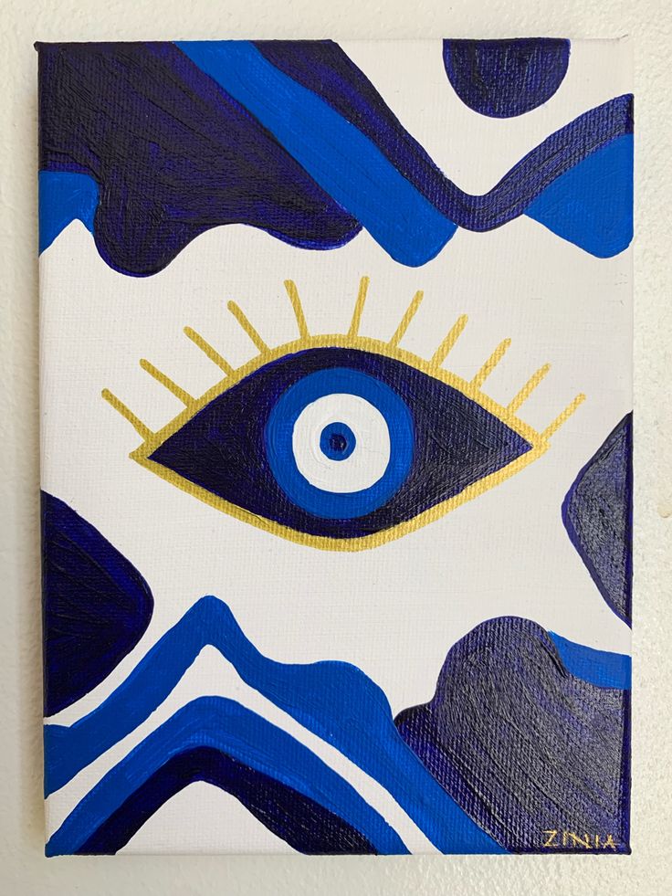 an eye is painted on a canvas with blue and white colors, as well as gold accents