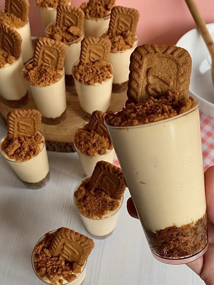 a person holding a cup with some desserts in it