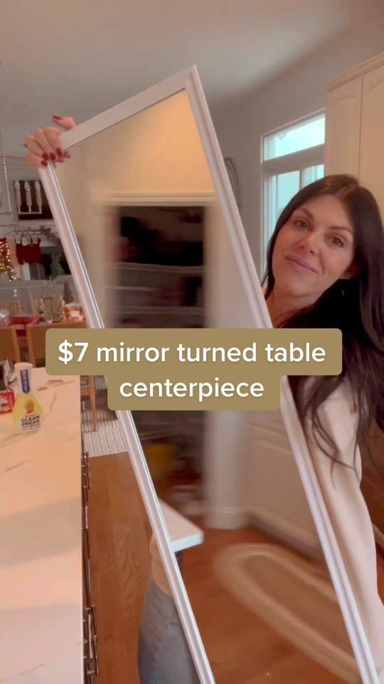 a woman standing in front of a mirror with the words $ 7 mirror turned table centerpiece