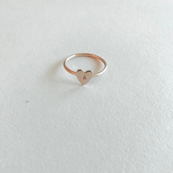 Make a sentimental statement with this custom ring. The heart pendant is so pretty and is a romantic addition to your ring stack. Choose up to three characters to show your love with our Heart Keepsake Ring. Materials: 14k Gold Fill, 14k Rose Gold Fill, Sterling Silver Measurements: .25” Heart Charm Valentine's Day Rose Gold Stackable Rings, Rose Gold Heart Ring Valentine's Day Gift, Simple Rose Gold Heart Jewelry, Dainty Heart Charm Stackable Gift Rings, Dainty Stackable Gift Rings With Heart Charm, Minimalist Stackable Rings With Heart Charm For Anniversary, Dainty Stackable Heart Ring Gift, Dainty Initials Jewelry For Promise, Rose Gold Open Ring Jewelry For Valentine's Day