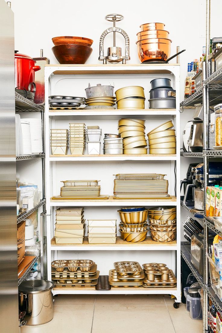 an organized pantry with lots of food items on shelving and shelves filled with pots, pans, and bowls