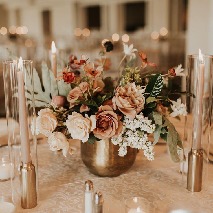 there is a vase with flowers and candles on the table