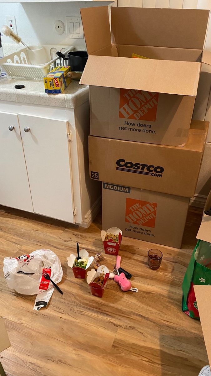 the kitchen floor is littered with boxes and other items that have been placed on it