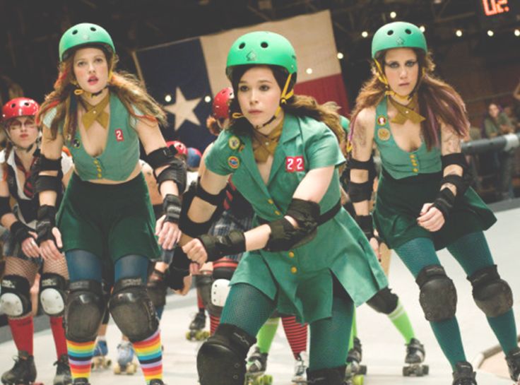 several girls in green uniforms are roller skating