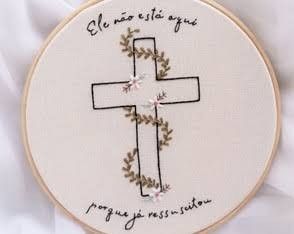 a cross with flowers on it is embroidered onto a white cloth