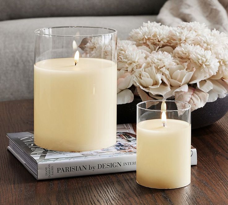 two candles sitting on top of a table next to a vase with flowers in it