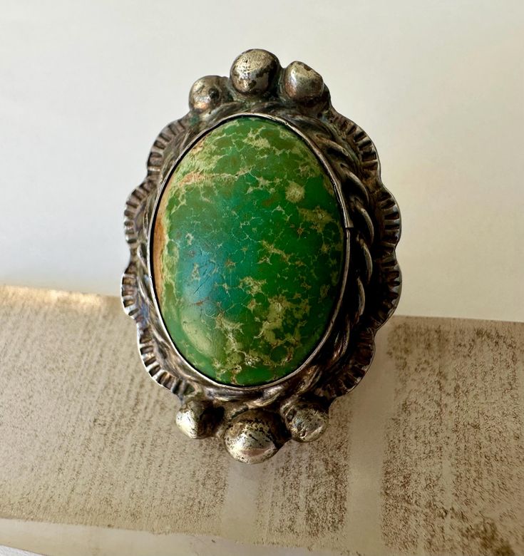 a pretty spectacular old ring, large, with a wonderful green turquoise.  i am a huge fan of these old pieces of turquoise, and this ring, for that matter.  it's beautifully crafted with lots of detail and a scalloped edge.  it has some wear, both on the silver and the stone, but basically nice condition.  unmarked sterling. size:  7 height of face:  1 and 5/16" width of inner band:  3/16" Old Rings, Navajo Rings, Green Turquoise, Scalloped Edge, Ring Size 7, Rings Statement, Favorite Things Gift, Labour Day, Statement Rings