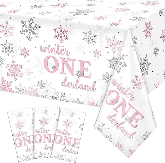 the table cloth has pink and silver snowflakes on it, along with matching napkins