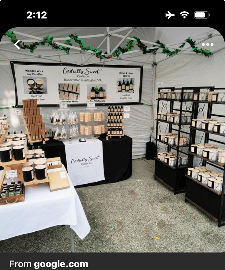 an outdoor market with lots of items on the tables and in front of it is a sign that says gourmet