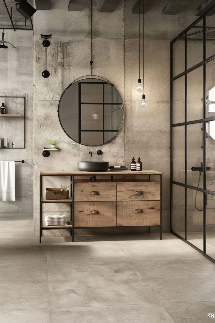 an industrial bathroom with concrete walls and flooring is seen in this image, there are mirrors on the wall above the sink