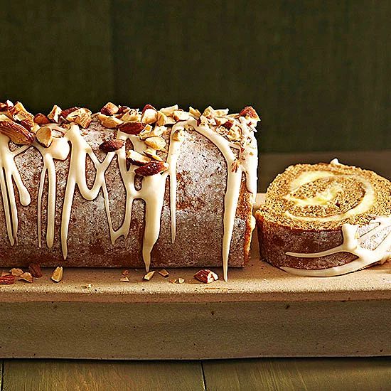 a loaf of bread sitting on top of a wooden cutting board next to a pastry