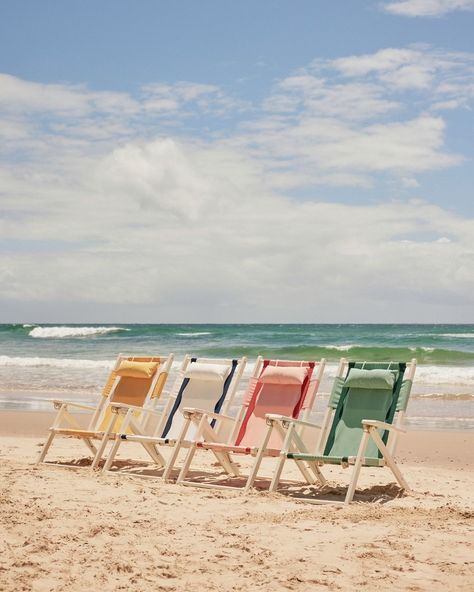 four beach chairs are lined up on the beach