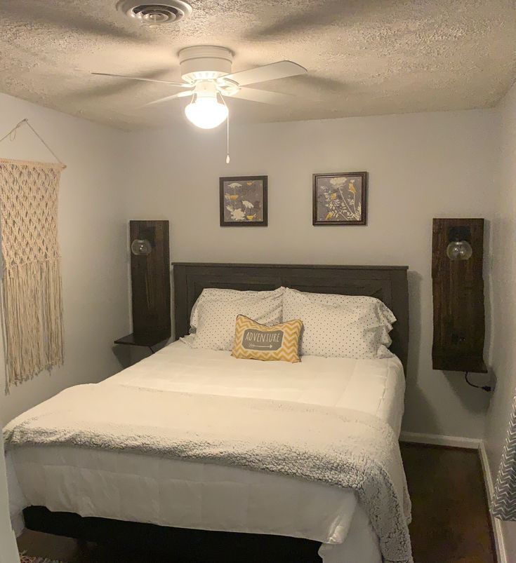 a bedroom with a white bed and two pictures on the wall