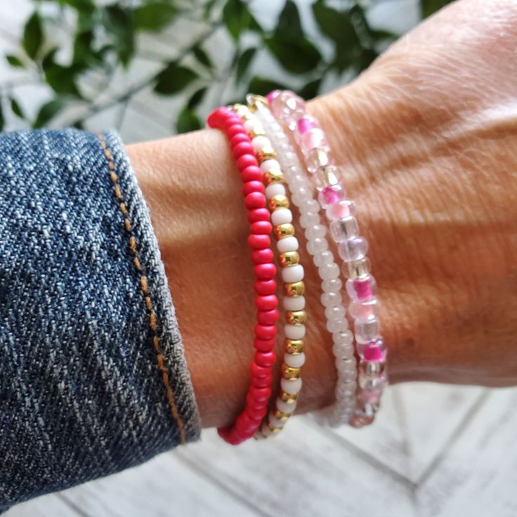 a woman's arm with three bracelets on top of her wrist and two other bracelet