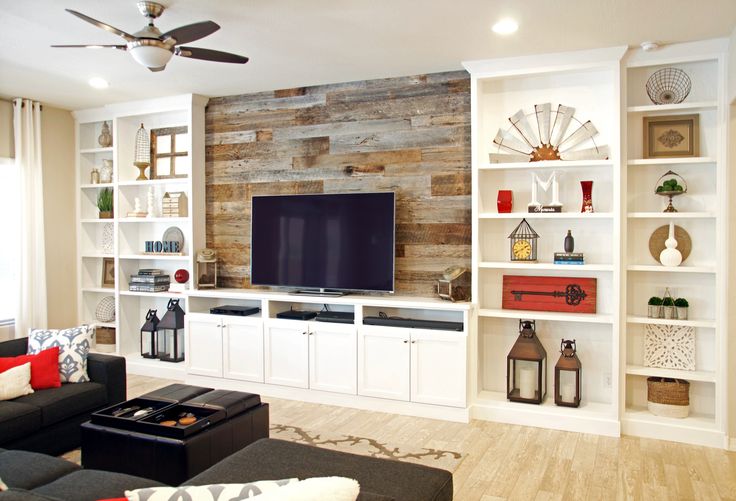 a living room filled with furniture and a flat screen tv mounted on a wall next to a window