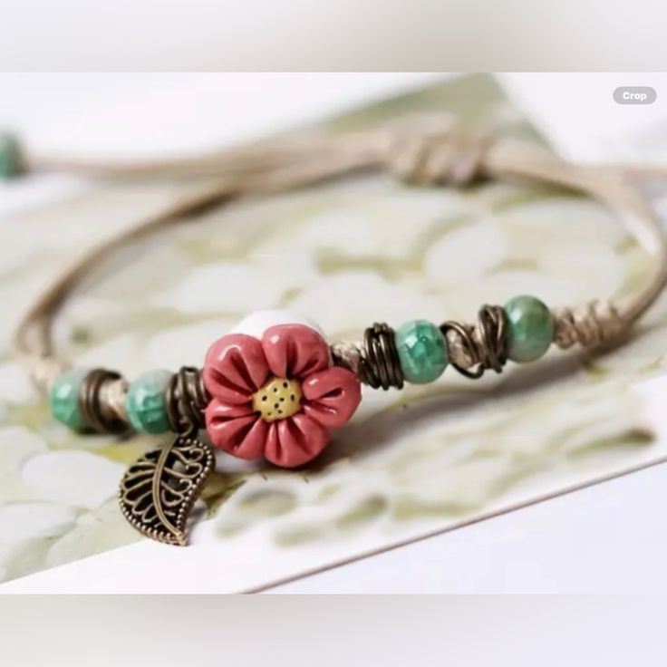 a bracelet with flowers and leaves on it