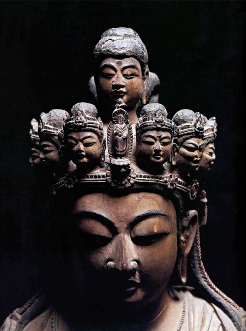 a statue with many heads on it's head and eyes closed to the side