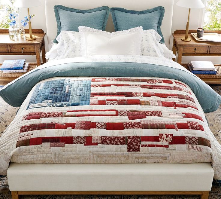 a bed with a red, white and blue quilt on it