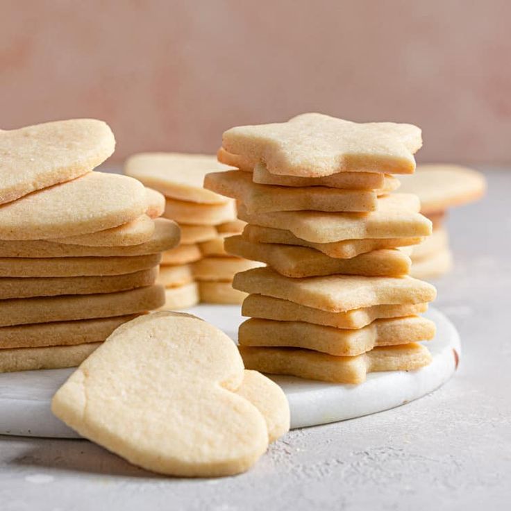 a stack of cookies sitting on top of a white plate next to a pile of cookies